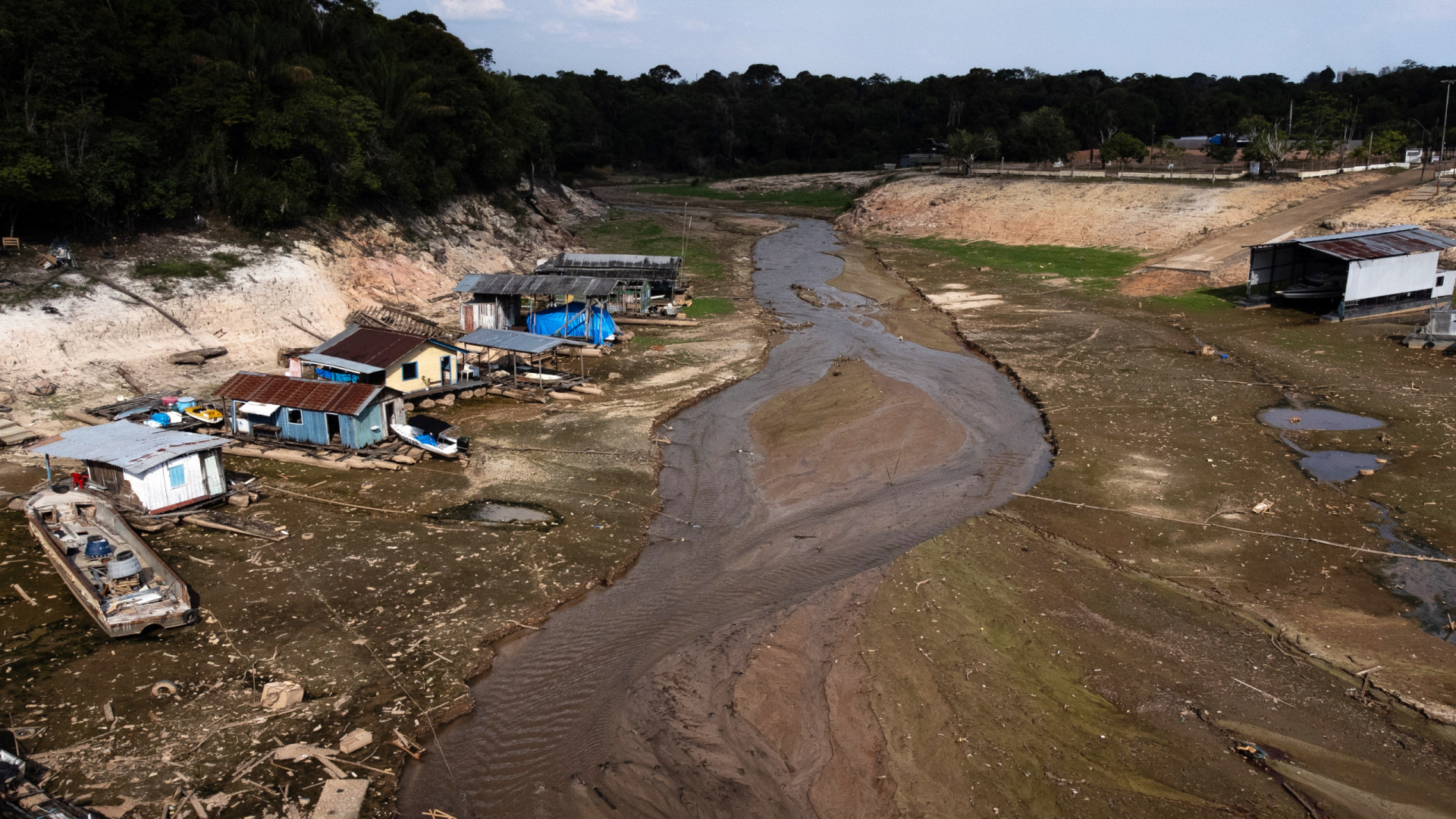 Seca na Amazônia faz rio desaparecer, e ribeirinhos percorrem bancos de areia com água da cidade